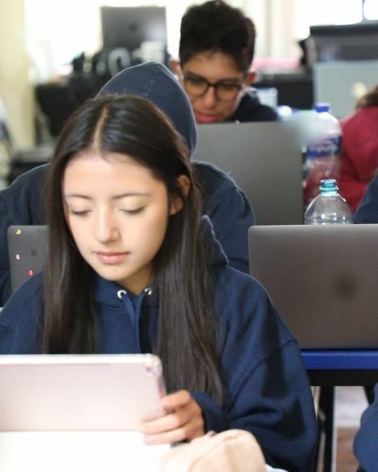Una alumna de preparatoria lee en su tableta durante la clase