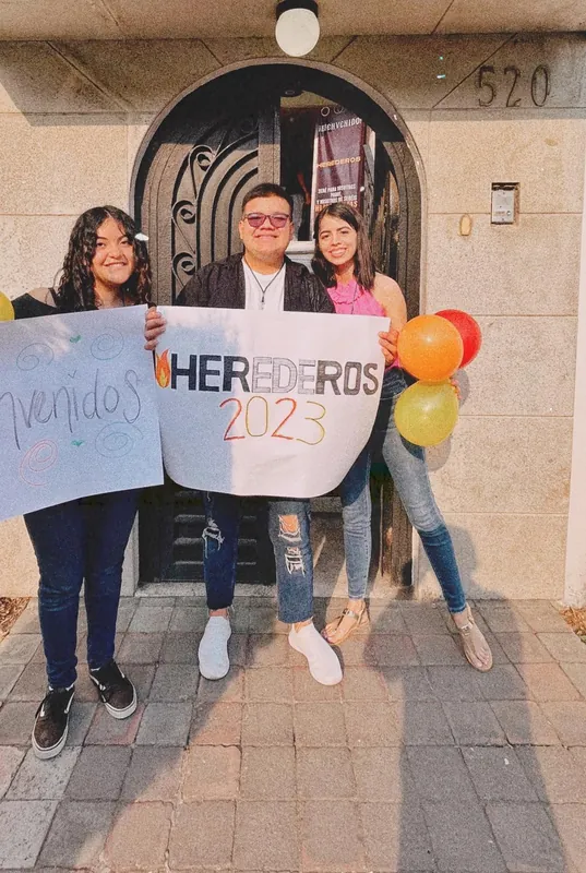 Jóvenes dan la bienvenida con carteles de Herederos 2023